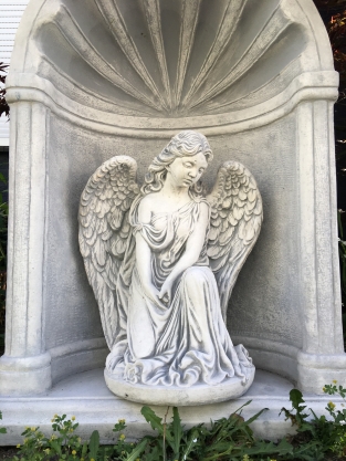 Fraai knielend engelbeeld vol steen in bidkapel vol steen.